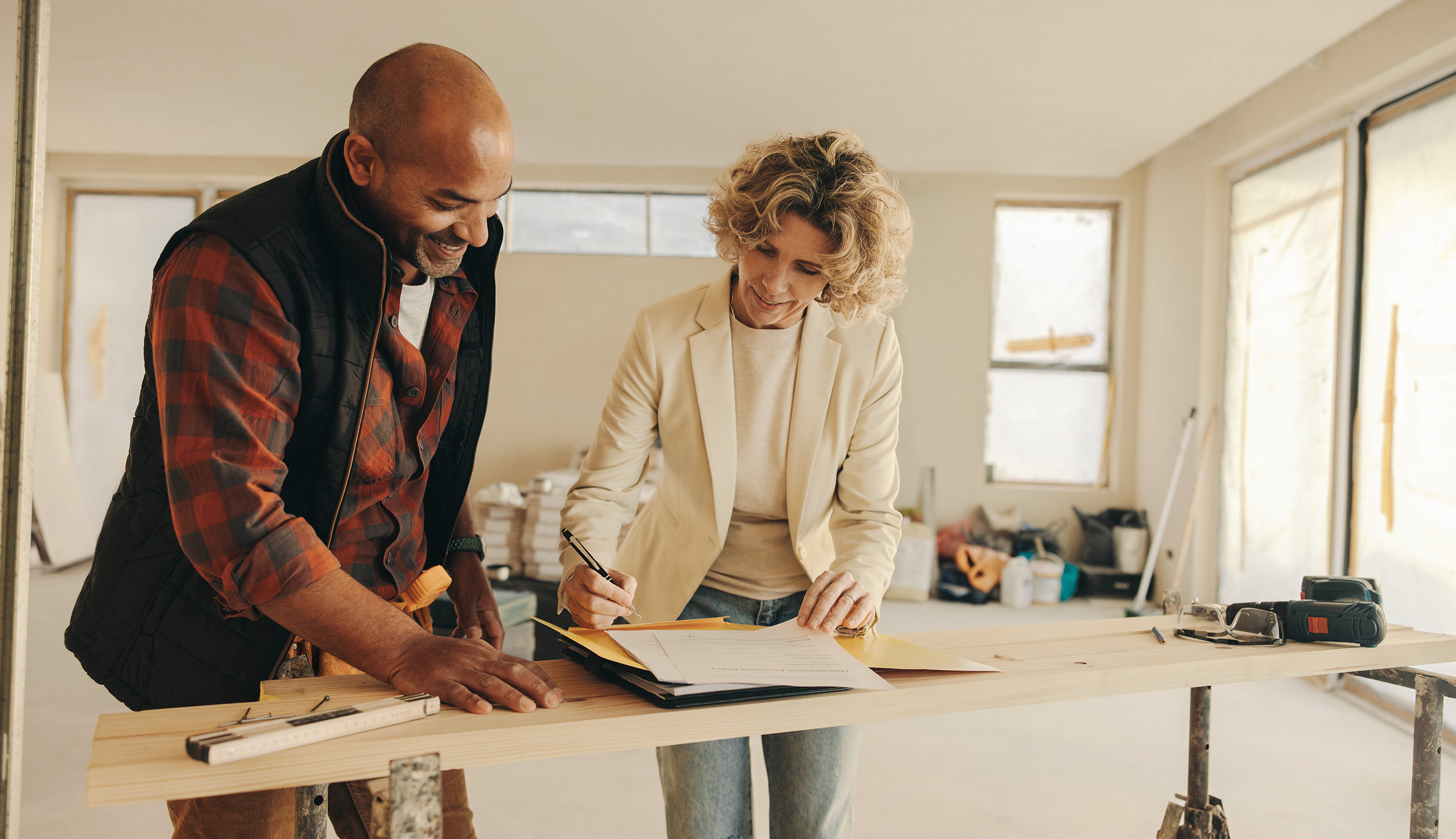 A lady and a contractor going through their plans for their renovation