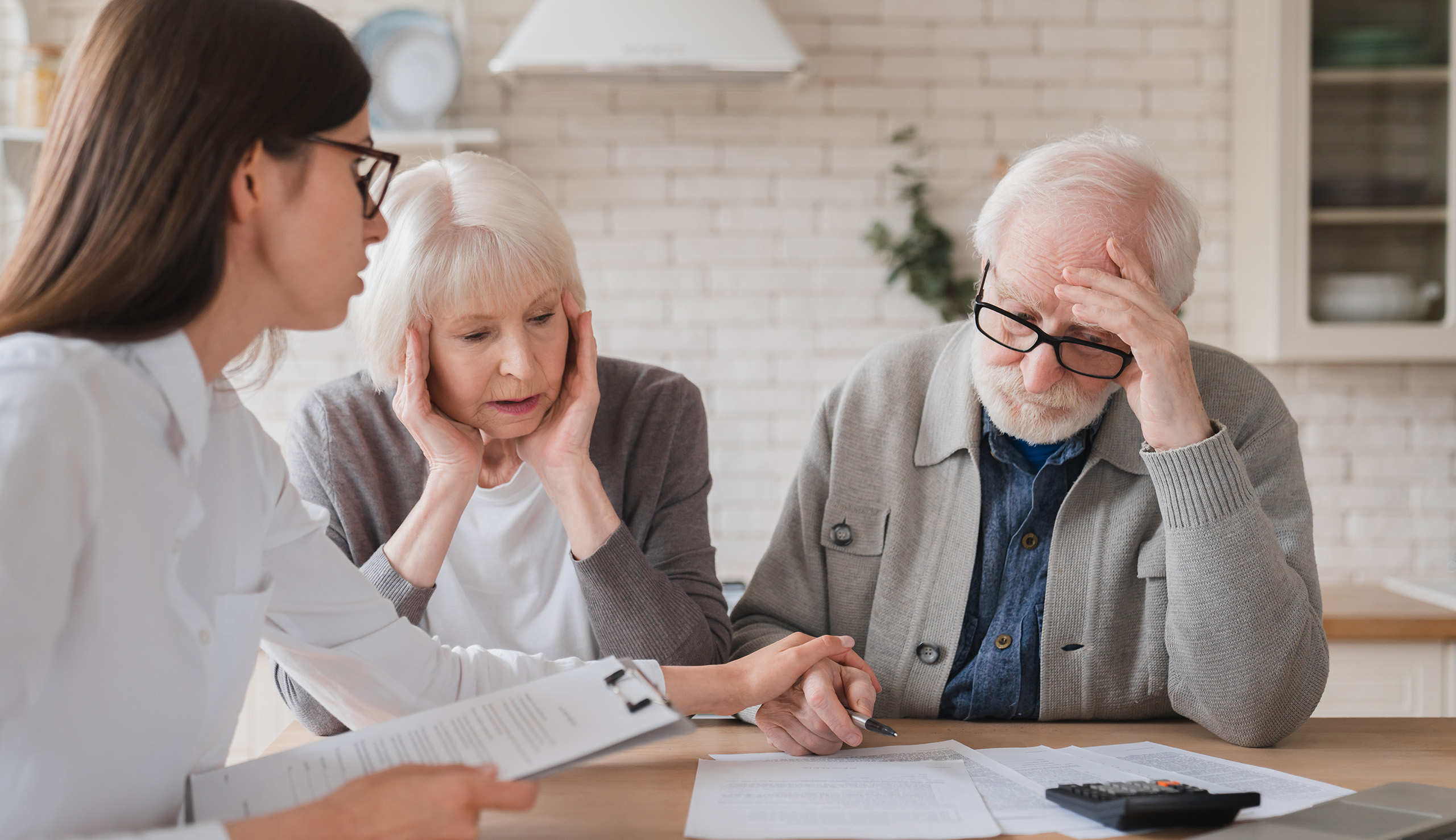 An older man and woman talking to their mortgage broker