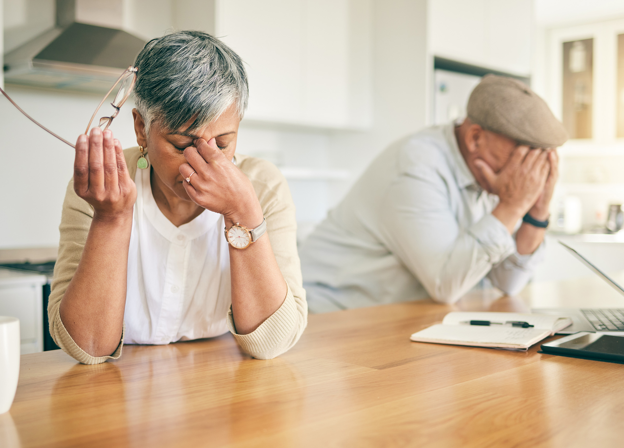 Older man and woman looking stressed around the kitchen island